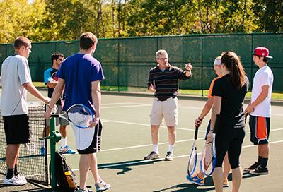 Students on outdoor tennis courts on campus